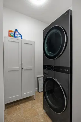 a washing machine and a dryer in a room at The Copperleaf Luxury Retreat with Hot tub in Calgary