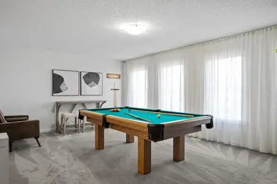 a living room with a pool table in it at The Copperleaf Luxury Retreat with Hot tub in Calgary