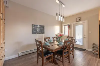 a dining room with a wooden table and chairs at Comfort Tenacity in Yellowknife