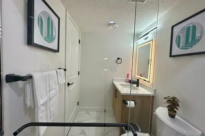 a bathroom with a shower and a toilet and a sink at Sleek Guest Retreat SW EDM BSMT Suite in Edmonton