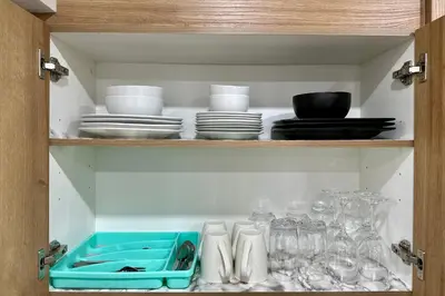a cabinet filled with dishes and bowls and plates at Sleek Guest Retreat SW EDM BSMT Suite in Edmonton