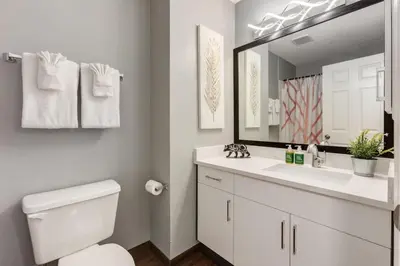 a white bathroom with a toilet and a large mirror at Stunning 3BR Escape with Mountain Views in Canmore in Canmore
