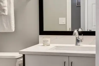 a white bathroom with a sink and a mirror at Stunning 3BR Escape with Mountain Views in Canmore in Canmore