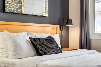 a bed with a black and white pillow on it at Stylish 3BR Condo in DT Canmore in Canmore