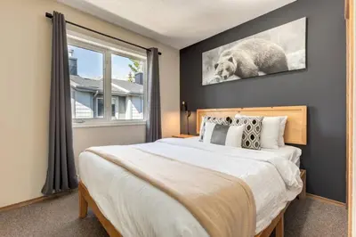 a bedroom with a large bed and a window at Stylish 3BR Condo in DT Canmore in Canmore