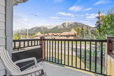 a balcony with two chairs and a view of mountains at Great Rocky Mountain 3BR Condo in Canmore DT in Canmore