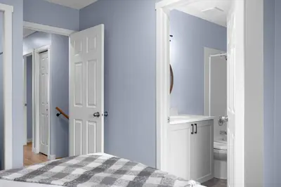 a bedroom with a bed and a bathroom with a sink at Great Rocky Mountain 3BR Condo in Canmore DT in Canmore