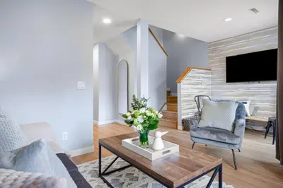 a living room with a vase of flowers on a coffee table at Great Rocky Mountain 3BR Condo in Canmore DT in Canmore