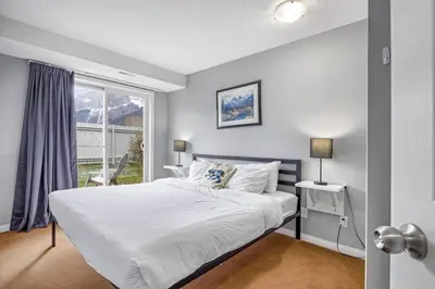 a bedroom with a large bed and a window at Spacious 2BR unit near DT Canmore and Banff in Canmore