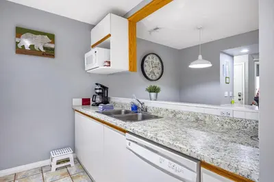 a kitchen with a sink and a clock on the wall at Spacious 2BR unit near DT Canmore and Banff in Canmore