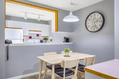 a kitchen and dining room with a table and a clock at Spacious 2BR unit near DT Canmore and Banff in Canmore