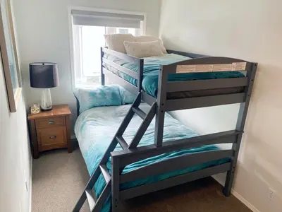 a bedroom with two bunk beds and a window at Rockies 3BR Townhome w Stunning Views Near DT in Canmore