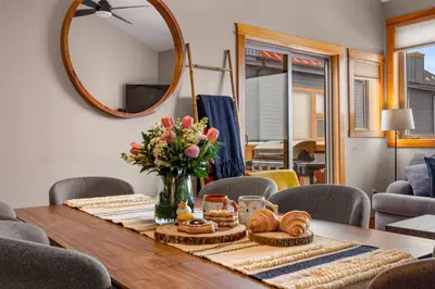 a table with a vase of flowers and a mirror at 3BR Luxury Top Floor Condo with Great views in Canmore