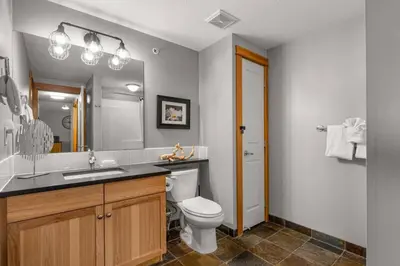 a bathroom with a toilet and a sink and a mirror at 3BR Luxury Top Floor Condo with Great views in Canmore