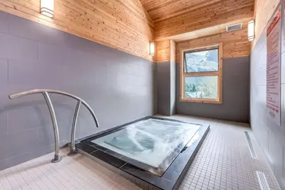 a bathroom with a hot tub with a window at 3BR Luxury Top Floor Condo with Great views in Canmore