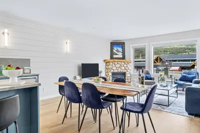 a kitchen and living room with a table and chairs at Newly Renovated 3BR Condo with Hot Tub and MTN Views in Canmore