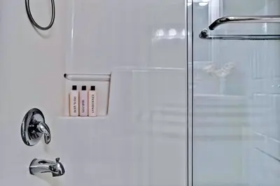 a shower with a glass door and a sink at Newly Renovated 3BR Condo with Hot Tub and MTN Views in Canmore