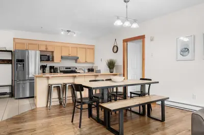 a kitchen with a table and chairs in a room at Spacious 3 BR Condo with Gym and Hot tub in Canmore
