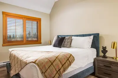 a bedroom with a large bed and a window at Spectacular 3BR Mountain Views with Hot Tub and Gym in Canmore