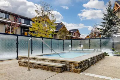 a hot tub in front of a fence at Comfy 2BR Minutes from Downtown with Hot Tub in Dead Man's Flats