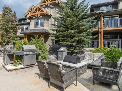 a backyard with a grill and chairs and a house at Comfy 2BR Minutes from Downtown with Hot Tub in Dead Man's Flats