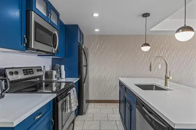 a kitchen with blue cabinets and a sink at Free Arcade Delightful Stay in Rocky Mountains in Dead Man's Flats