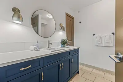 a bathroom with a blue sink and a mirror at Free Arcade Delightful Stay in Rocky Mountains in Dead Man's Flats