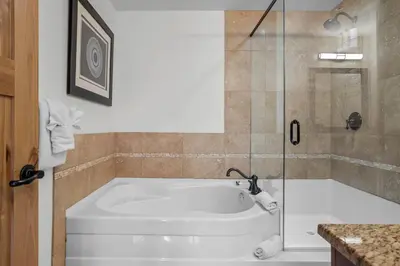 a bath tub in a bathroom with a shower at Mountain Views Lux 2BR Condo in Canmore with Hot Tub in Canmore