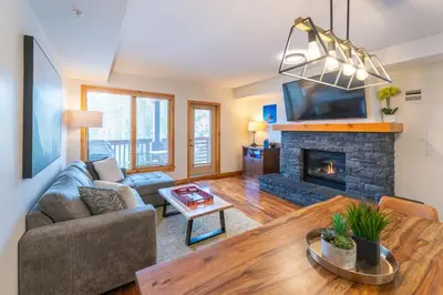 a living room with a couch and a fireplace at Serene 3BR Rockies Stay with Hot Tub and Near DT in Canmore