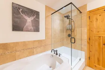 a bath tub in a bathroom with a shower at Serene 3BR Rockies Stay with Hot Tub and Near DT in Canmore