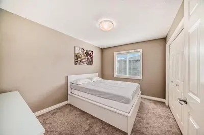 a small bedroom with a bed and a window at Waterfront Home, Fireplace, 90 min to Banff in Airdrie