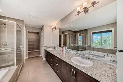 a large bathroom with two sinks and a shower at Waterfront Home, Fireplace, 90 min to Banff in Airdrie