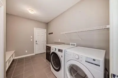 a laundry room with a washer and dryer in it at Waterfront Home, Fireplace, 90 min to Banff in Airdrie