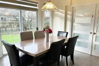 a dining room table with chairs and a vase with flowers at Two Bedrooms One King Bed and One Double Bed in Richmond