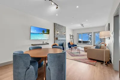 a living room with a table and chairs and a living room at Western Star Chalet Ski in out and Amazing Mtn View in Big White