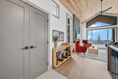 a hallway with a door leading to a living room at Western Star Chalet Ski in out and Amazing Mtn View in Big White