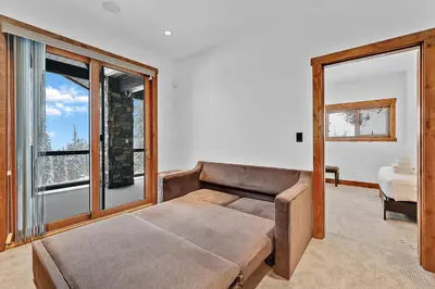 a living room with a couch and a large window at Western Star Chalet Ski in out and Amazing Mtn View in Big White