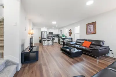 a living room with a leather couch and a table at Spacious Home • 3BR • Close to Whyte and Downtown in Edmonton