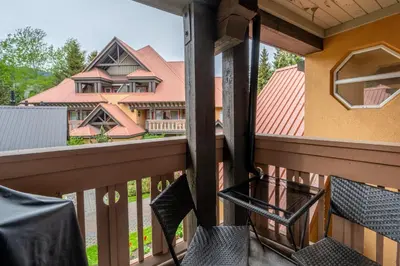 a balcony with chairs and a view of a house at Private Hot Tub | Pool | AC | Free Parking in Whistler