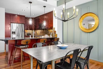 a kitchen with a table and chairs and a mirror at Luxurious Condo Mountain Views Hot-tub and Billiards in Canmore