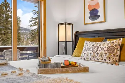 a bedroom with a bed with a tray of fruit on it at Luxurious Condo Mountain Views Hot-tub and Billiards in Canmore