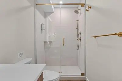 a white bathroom with a shower and a toilet at Sisters' Solstice Villa by WeekAway Vacations in Canmore