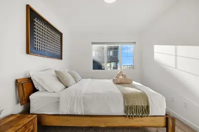 a bedroom with a bed with white sheets and a window at Luxury Family Retreat with Games, King Bed and Garage in Edmonton