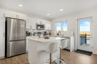 a kitchen with white appliances and a large kitchen island at Single Detached Full House with Ping Pong King Bed and Garage in Edmonton