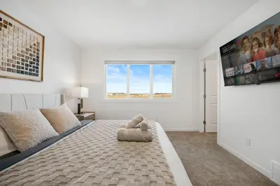 a bedroom with a bed and a large window at Single Detached Full House with Ping Pong King Bed and Garage in Edmonton