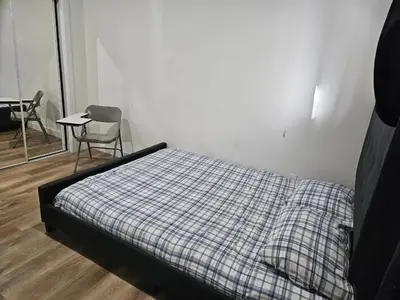 a bedroom with a bed and a table and a chair at Private room in Basement suite in Edmonton