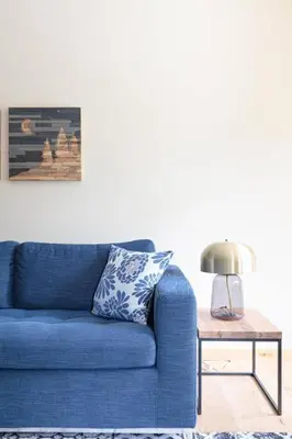 a blue couch in a living room with a table at Spring Creek Serenity at Rundle Cliffs Lodge in Canmore