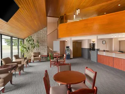 a waiting room with tables and chairs in a building at Canada Grey Motor Inn in Hanna