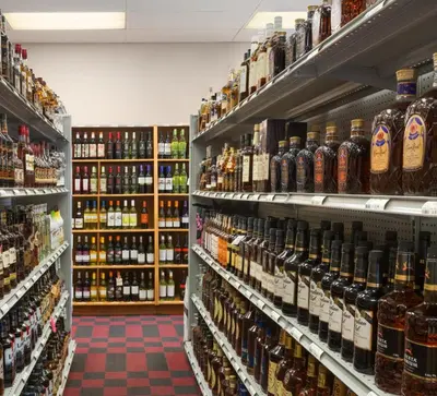 a store aisle filled with lots of bottles of beer at Canada Grey Motor Inn in Hanna
