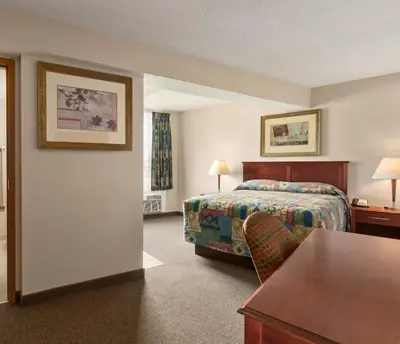 a hotel room with a bed and a table at Canada Grey Motor Inn in Hanna